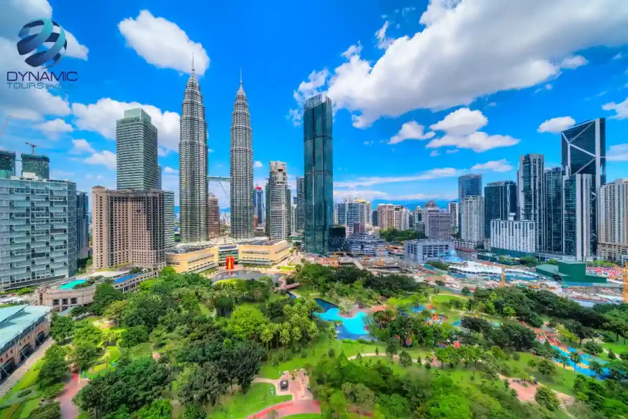 Travel poster featuring Kuala Lumpur skyline with Petronas Twin Towers, modern skyscrapers, and lush green park under bright blue sky